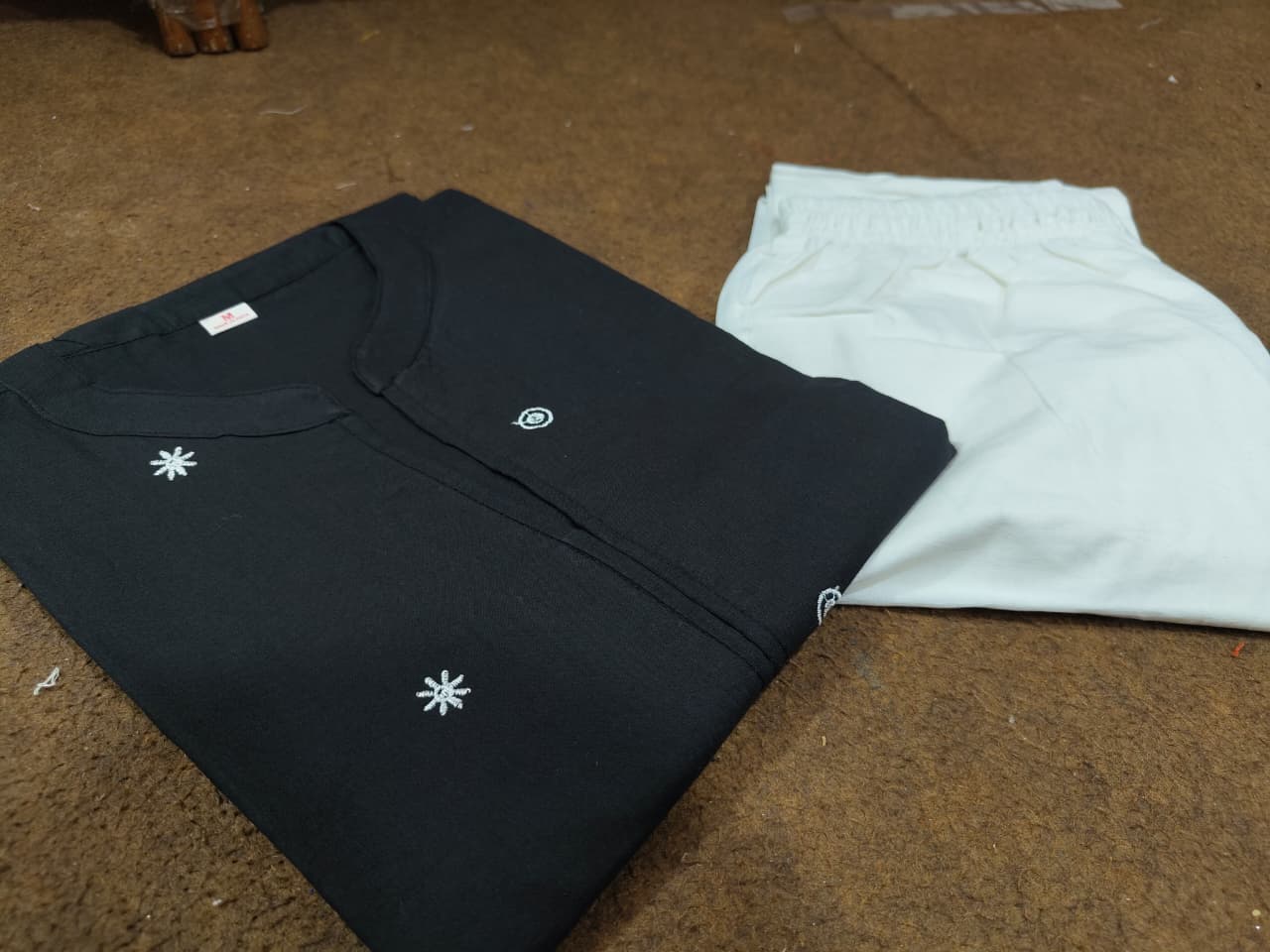 Black embroidered kurti front view on hanger
